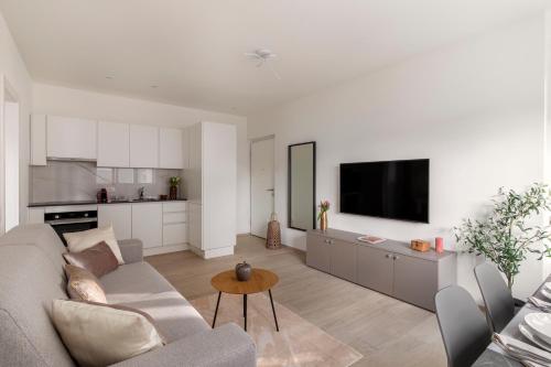 a white living room with a couch and a table at Lugano Superior Suites - Free Parking in Lugano