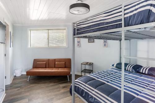 a bedroom with a bunk bed and a chair at Peaceful Lydia Hide-O-Way - Unwind Near Beach, Breakfast, Spa & Go-Karts! in Panama City Beach