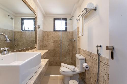 a bathroom with a sink and a toilet and a shower at H4 La Residence Paulista in Sao Paulo