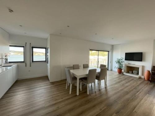a dining room and kitchen with a table and chairs at Apartamento em frente à Praia in São Martinho do Porto