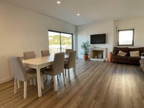 uma sala de jantar com uma mesa e cadeiras numa sala de estar em Apartamento em frente à Praia em São Martinho do Porto