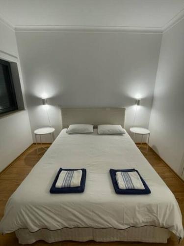 a bedroom with a large bed with two trays on it at Apartamento em frente à Praia in São Martinho do Porto