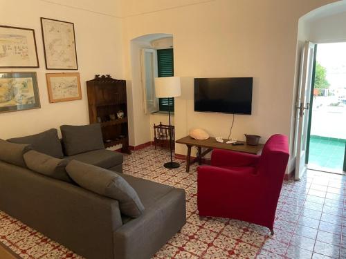 a living room with a couch and a chair and a television at Agenzia Isotur La Magnolia in Ponza