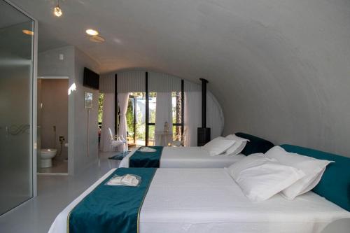 a bedroom with a large bed and a bathroom at Aton Cabanas Boutique in Canela