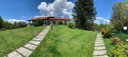 a house on a grassy hill with a pathway at Casa Vacanze AL CAPRIANO appartamento Mora in Cantello