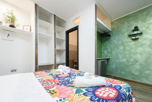 ナポリにあるLoft by B&B Universitàのベッドルーム1室(カラフルなベッド1台、タオル付)
