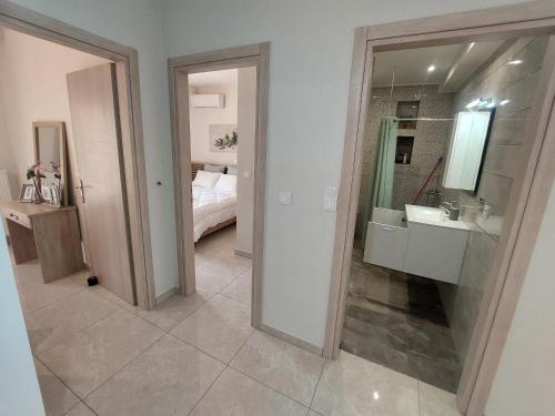a bathroom with a sink and a mirror at Myrsini’s sea view apartment in Nea Peramos