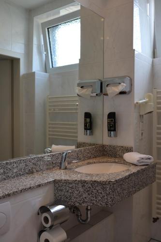 a bathroom with a sink and a mirror at Thuns Dorfkrug in Werdohl