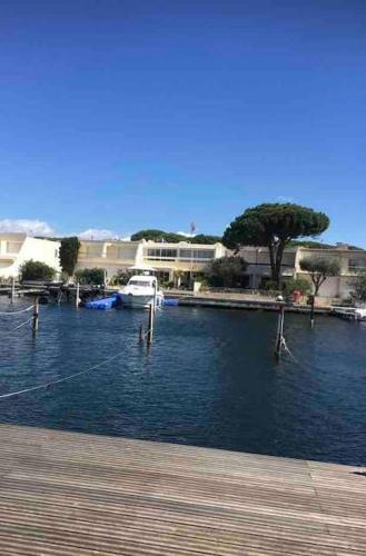un port de plaisance avec un bateau blanc dans l'eau dans l'établissement Belle grande marina en duplex avec appontement, au Grau-du-Roi