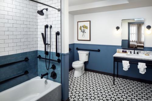 a bathroom with a tub and a toilet and a sink at Hotel Indigo - Omaha Downtown, an IHG Hotel in Omaha