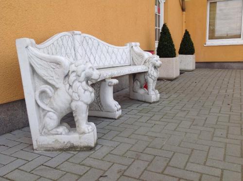 a white bench sitting outside of a building at Pension an der Werft in Rostock