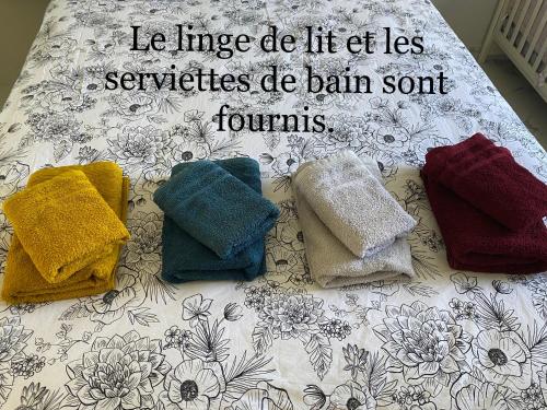 un groupe de serviettes posées sur un lit dans l'établissement Studio climatisé avec piscine et jardin, à Villeneuve-Loubet