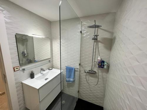 a white bathroom with a shower and a sink at اقامة الاحلام in Nador
