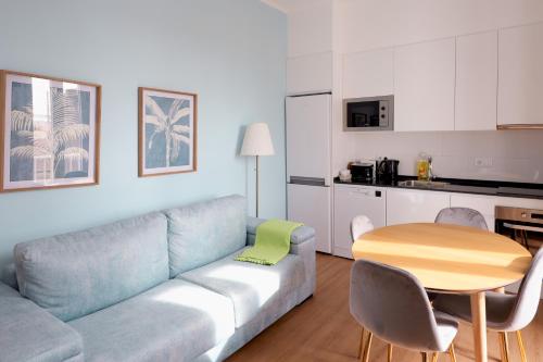 a living room with a couch and a table and a kitchen at Apartment Ajuda Tagus River View in Lisbon