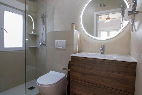 a bathroom with a toilet and a sink and a mirror at La Lagunilla Golf in Candeleda