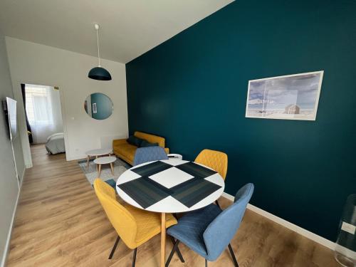 une salle à manger avec une table et des chaises dans l'établissement Immeuble Bavay 3 apparts, 4 Chambres, 5 ambiances, à Valenciennes