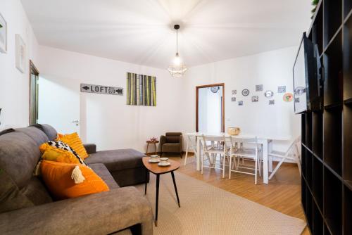 een woonkamer met een bank en een tafel bij Apt Boavista 3bdr Casa da música in Porto