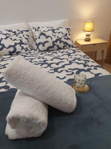 a bed with white towels on it with a lamp at Casa en piedra (Stone House) in Porriño