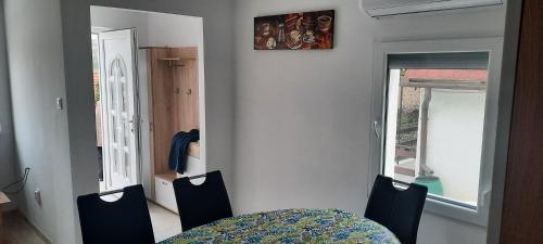 uma sala de jantar com uma mesa e cadeiras e uma janela em Boróka Ház em Orfű