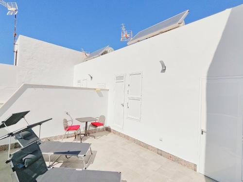 a white building with a table and chairs on a patio at Gemini Conil in Conil de la Frontera