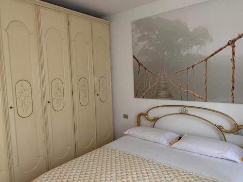 a bedroom with a bed and a painting on the wall at Casa Vacanze AL CAPRIANO appartamento Mora in Cantello