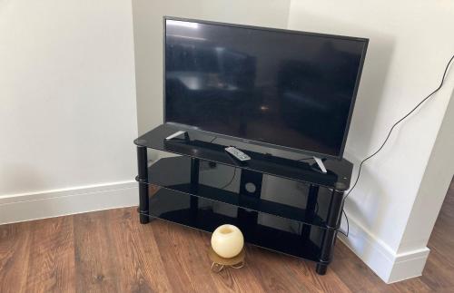 a flat screen tv on a black entertainment center at Elite Wolverhampton short/long stays in Wolverhampton