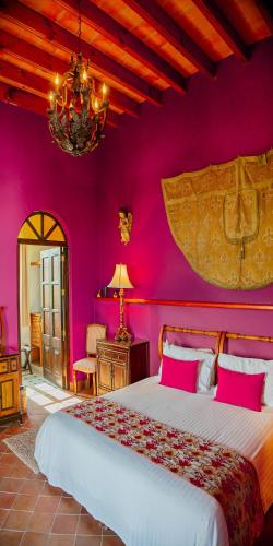 a bedroom with a large bed with pink walls at Casa Don Pascual Hotel Boutique Sweet Home in San Miguel de Allende