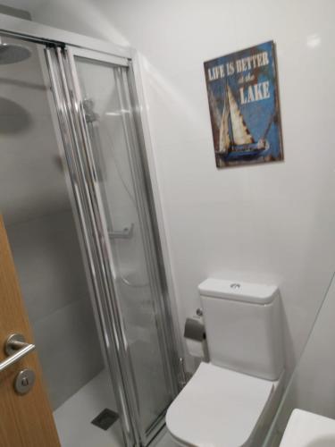 a bathroom with a toilet and a sign on the wall at Casa en piedra (Stone House) in Porriño