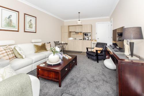 ein Wohnzimmer mit einem Sofa und einem Tisch in der Unterkunft Sweet Magnolia 1 or 2 BR Suite St Kilda Cambridge with Complimentary Continental Breakfast in Cambridge