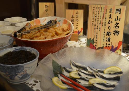 a table with a plate of food and a bowl of food at Hotel Excel Okayama in Okayama