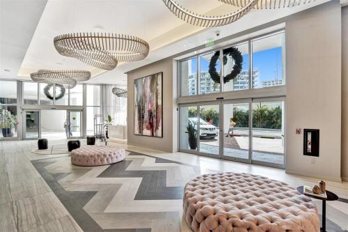 a large lobby with a large ottoman and large windows at Hyde Beach House - 2BD-2BA MANSION WITH DIRECT OCEAN VIEW, Resort Amenities, Rooftop Pool and Hot tub, Tennis court, few min walk to the ocean in Hollywood