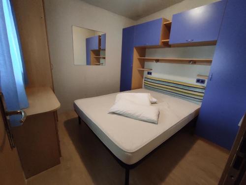 a small bed in a small room with blue cabinets at L'Oasi di Lulu' in Senigallia