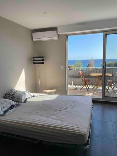 - une chambre avec un lit et une vue sur une terrasse dans l'établissement Studio VUE MER terrasse, à La Ciotat