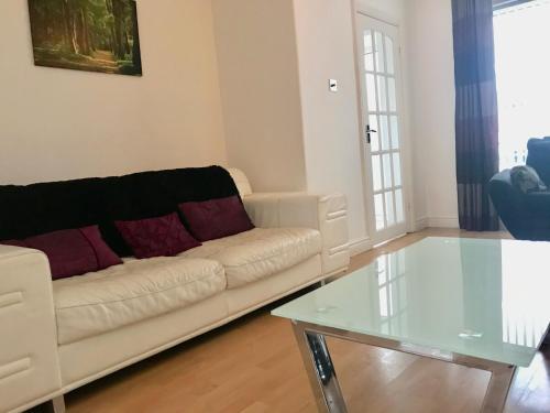 een woonkamer met een witte bank en een glazen tafel bij Willow in Foleshill