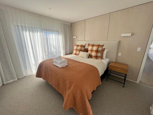 a bedroom with a large bed and a large window at Tekapo Toi Toi in Lake Tekapo