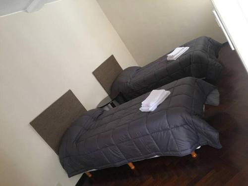 a bedroom with a black bed and a chair at Hermosa casa tranquila en la ciudad in Mendoza