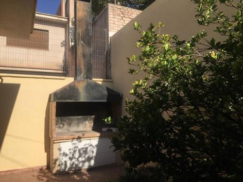 um forno a lenha sentado ao lado de um edifício em Hermosa casa tranquila en la ciudad em Mendoza