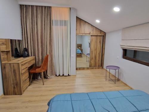 a room with a bedroom with a bed and a table at Cottage in Racha Mero in Nikortsminda