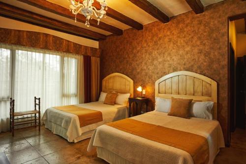 a hotel room with two beds and a chandelier at Uzhupud Garden Hotel & Lodge in Paute