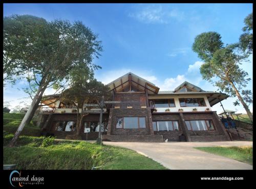 a large house with a tree in front of it at Destiny - The Farm Resort in Ooty
