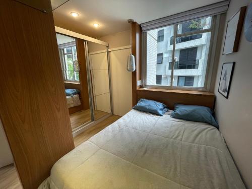 a small bedroom with a bed and a window at Duas Suítes e o Cristo Redentor in Rio de Janeiro