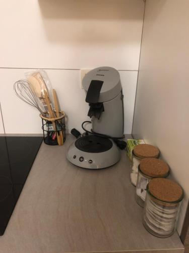 a kitchen counter with a coffee maker and a whisk at Pina's Appartment in Namur