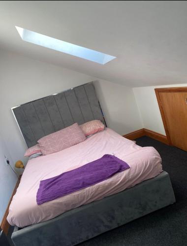 ルートンにあるBeautiful 2 Bedroom apartmentのベッドルーム1室(紫のシーツが敷かれた大型ベッド1台付)