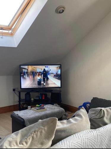 a living room with a flat screen tv on the wall at Beautiful 2 Bedroom apartment in Luton