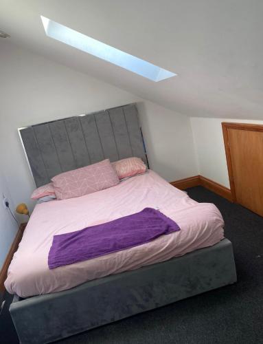 ルートンにあるBeautiful 2 Bedroom apartmentのベッドルーム1室(紫のシーツが敷かれた大型ベッド1台付)