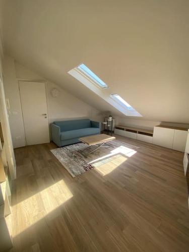 a living room with a blue couch in an attic at Deliziosa mansarda con vista panoramica in Cuneo