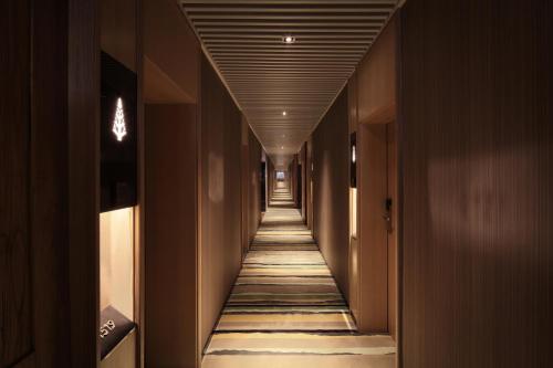 a hallway of a hotel with a long hallway of rooms at Bloom Boutique Hotel in Chongqing