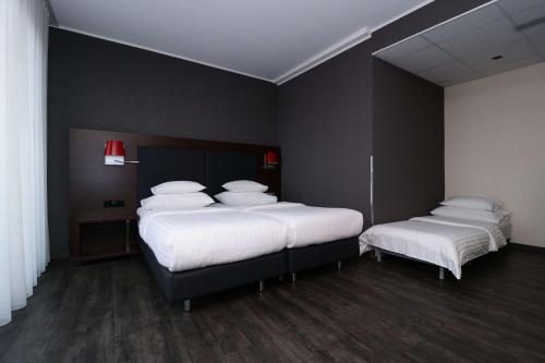 グラーツにあるBest Western Plus Plaza Hotel Grazのベッド2台(白いシーツ、枕付)