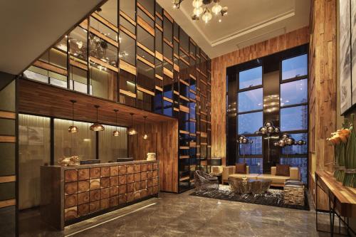 a lobby with a table and chairs and windows at Bloom Boutique Hotel in Chongqing