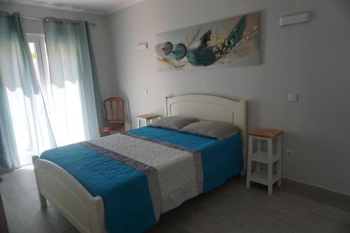 Schlafzimmer mit einem Bett mit blauer Decke in der Unterkunft Sunny Home in Amadora